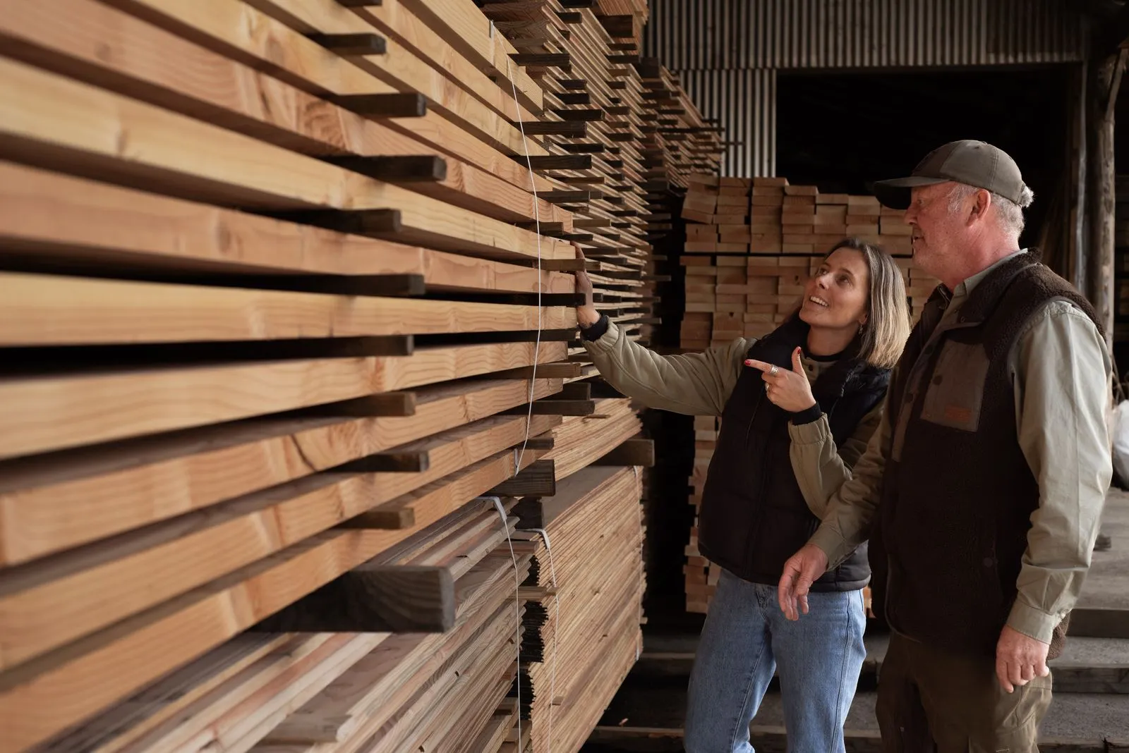Revisando tablas de madera en la bodega antes de despacharlas
