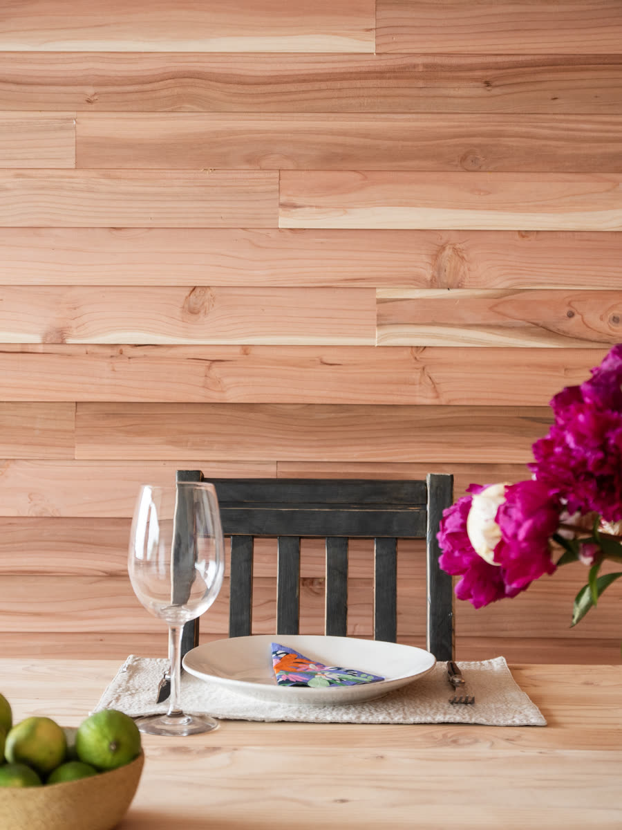Comedor con una pared revestida en madera de fondo