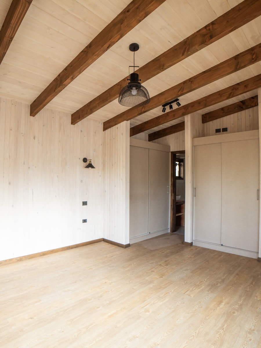 Dormitorio con cielo de vigas de pino oregón