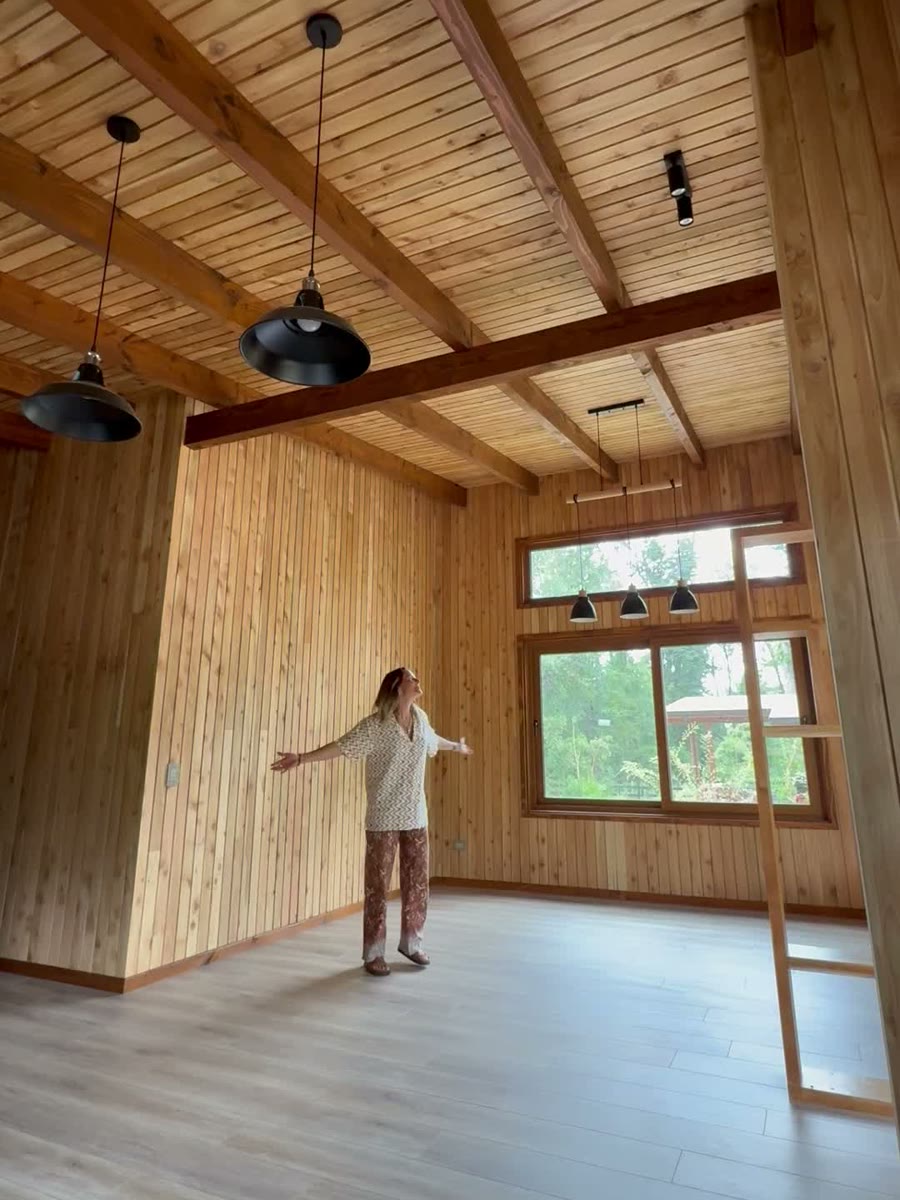 Espacio interior completamente revestido en Ciprés Thuja con vigas a la vista